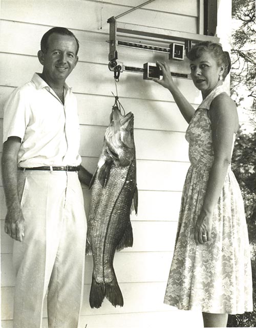 Frances Doucet weighing Jerry Pennock's big snook on the Fishing Club's front porch scale