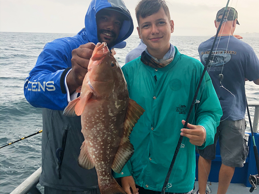 kid holding a grouper