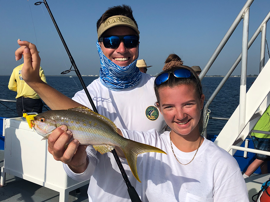 girl holding yellowtail snapper
